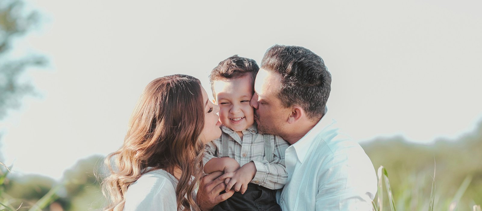 Parents embracing their smiling child, representing family security and protection