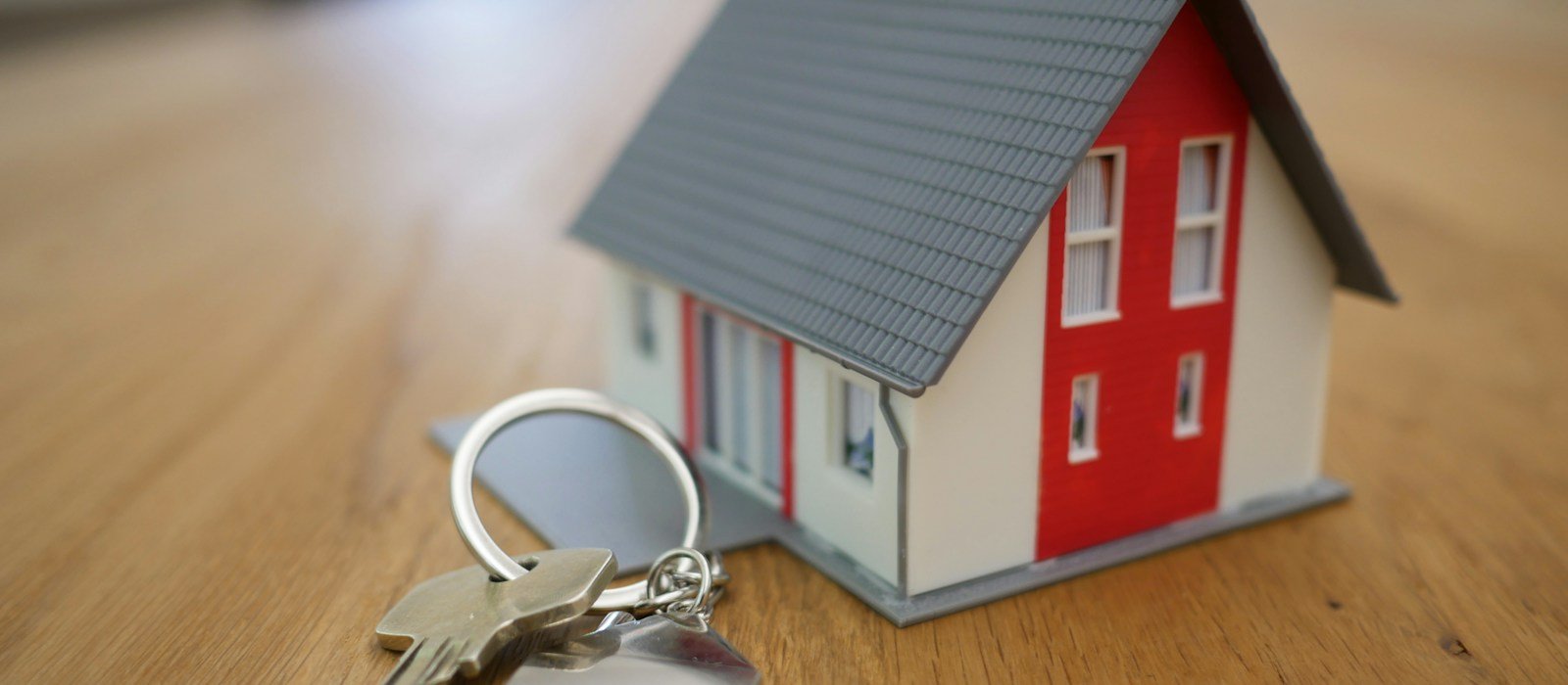 A model home and keys, representing property and asset insurance